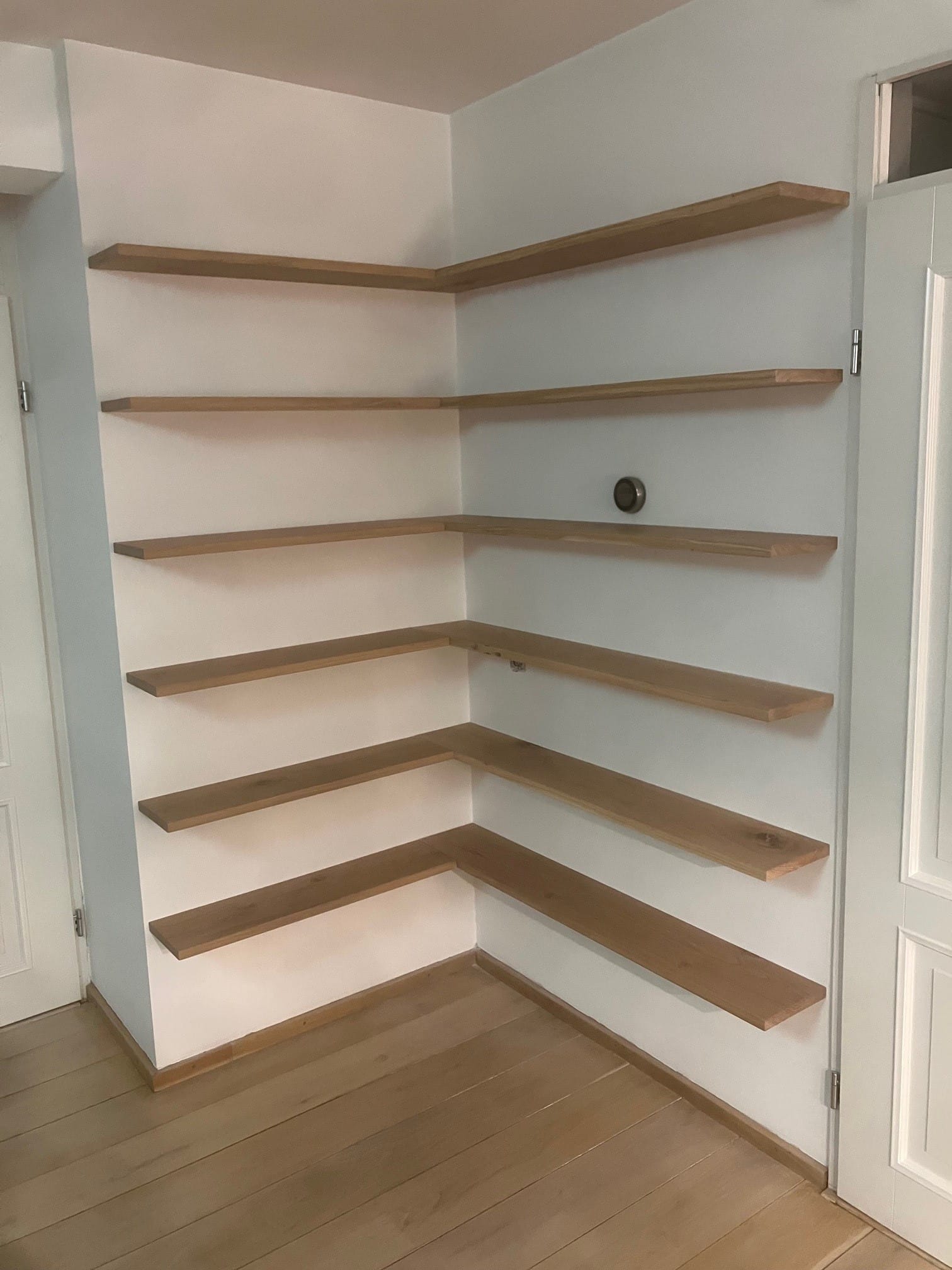 Meerdere eiken hoekplanken boven elkaar in een lichte kamer