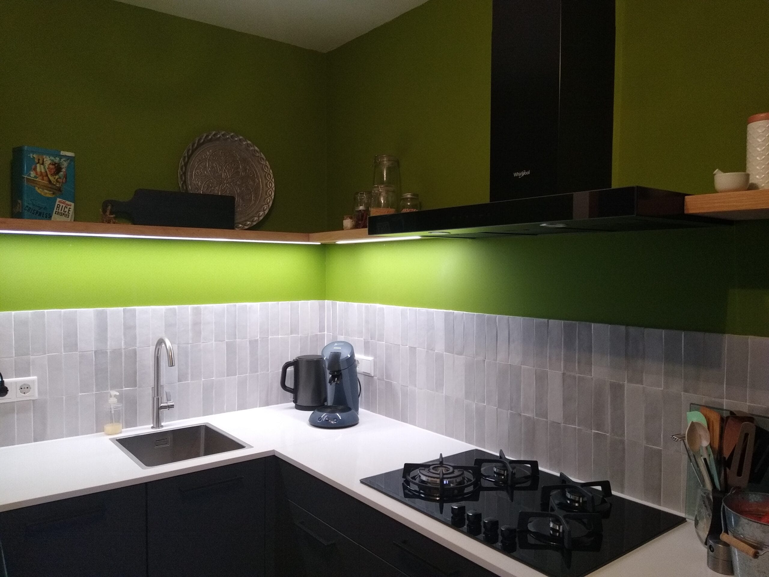 Eiken hoekplank met doorlopende LED-strip tegen groene keukenmuren